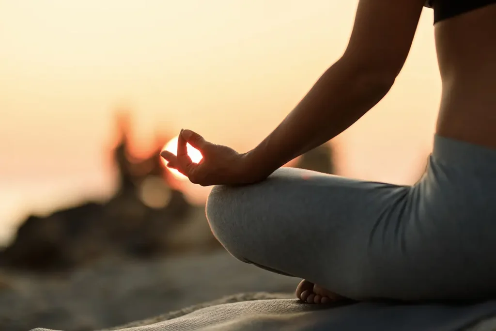 close-up-woman-meditating-lotus-position-sunset